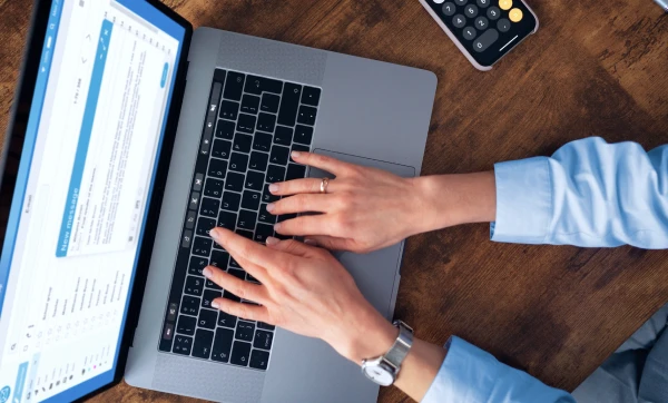 Profissional feminino usando notebook para controlar contratos recorrentes no GestãoClick.