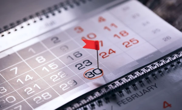 Calendario marcado no dia 30 com uma bandeira vermelha, representando: Como organizar o fechamento mensal da empresa para facilitar a contabilidade