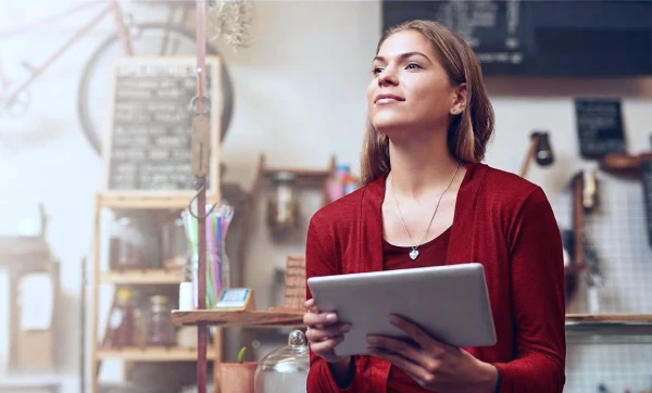 Empreendedora com tablet na mão representando: Gestão do tempo para microempresas: como o ERP libera horas produtivas do dono do negócio